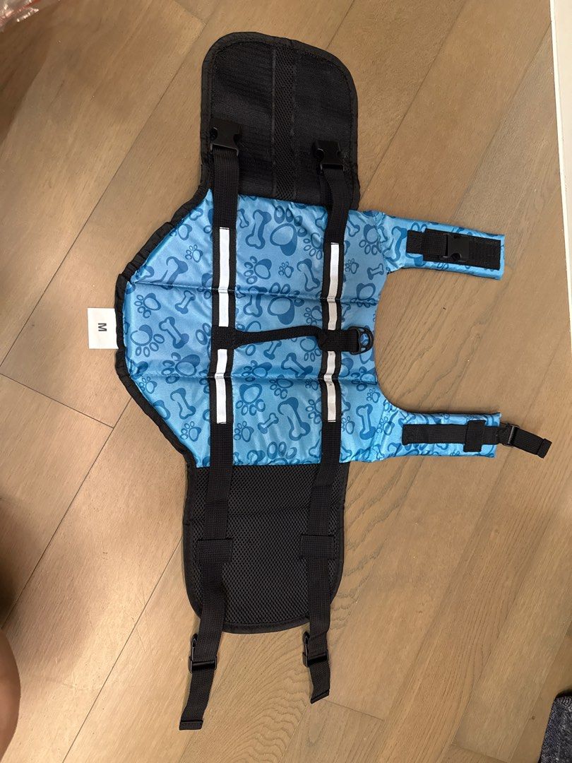 Dog Life Vest - Blue, Size M (Category: Homes & Other Pet Accessories) located in Singapore. Submitted by luvmyfood (Listing ID 1378384156, Image 1). Description: Blue dog life vest (Size M) with bone/paw print. Adjustable, reflective, and safe for water activities. Bought wrong size. .