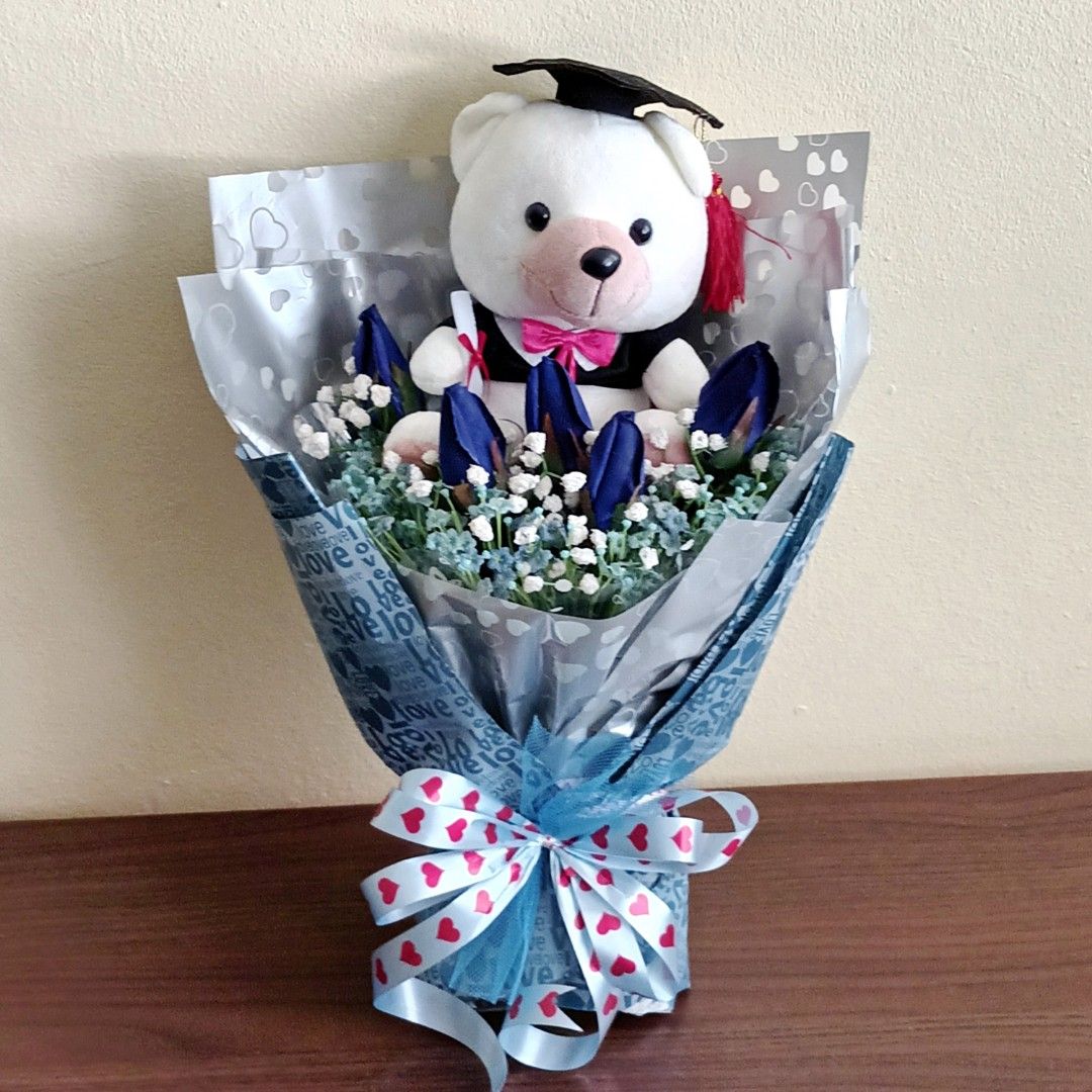 Graduation Bouquet-20cm Graduation Bear + Blue Roses + White & Blue Baby Breath (Category: Flowers & Bouquets) located in Singapore. Submitted by ManyThingsUC (Listing ID 1378428437, Image 1). Description: Height:45cmx Width 30cm 20cm Graduation Bear With Artificial Blue Velvet Roses +White & Blue Silk Baby Breath..
