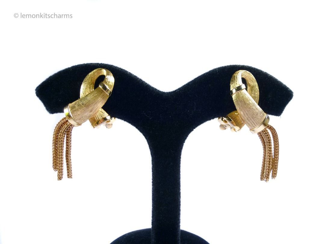 Vintage 1950s Looping Tassel Clip Earrings, er2675-ci (Category: Earrings) located in Singapore. Submitted by lemonkitscharms (Listing ID 1378460883, Image 1). Description: Vintage 1950s - 1960s Looping Tassel Clip Earrings. Unknown designer, clips are marked 'PAT.PEND.'. The quality is similar to Kramer or Trifari. Good condition, slight aging, minor wear, one earring has slight verdigris on the inner groove. Brushed goldtone loop design with ta