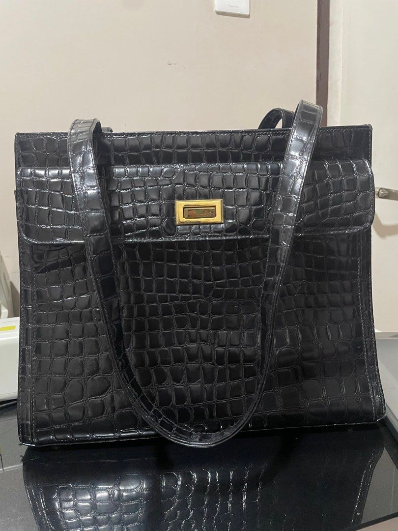 Tote bag black (Category: Shoulder Bags) located in Bocaue. Submitted by mommywins (Listing ID 1383988214, Image 2). Description: Looking for a stylish and functional bag? 🌟 Eto na! Selling this elegant black tote bag na perfect for work or schooling. ✨ Details: Material: Faux leather with crocodile-style texture (shiny finish) Color: Classic black Hardware: Gold-tone lock detail Strap: May dalawang long handles – pwedeng hand carry or shoulder 