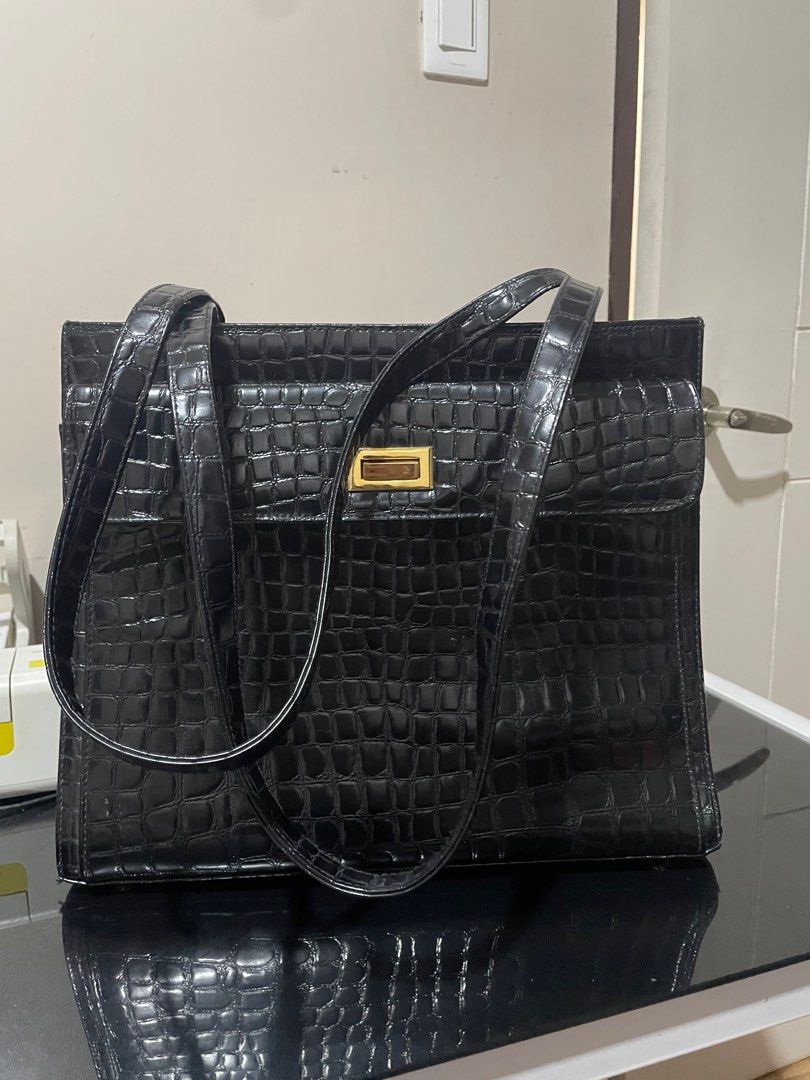 Tote bag black (Category: Shoulder Bags) located in Bocaue. Submitted by mommywins (Listing ID 1383988214, Image 1). Description: Looking for a stylish and functional bag? 🌟 Eto na! Selling this elegant black tote bag na perfect for work or schooling. ✨ Details: Material: Faux leather with crocodile-style texture (shiny finish) Color: Classic black Hardware: Gold-tone lock detail Strap: May dalawang long handles – pwedeng hand carry or shoulder 