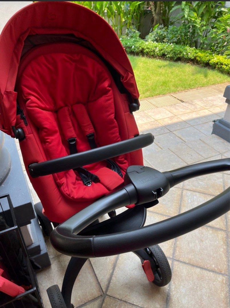 Stokke Xplory V6 Stroller - Red (Category: Strollers) located in Singapore. Submitted by muff85 (Listing ID 1378662793, Image 1). Description: Stokke Xplory V6 stroller in excellent condition. Features a vibrant red seat and a sleek black frame. Includes a comfortable seat with a 5-point harness. The stroller appears to be well-maintained and ready for use. Perfect for parents seeking style and functionality..