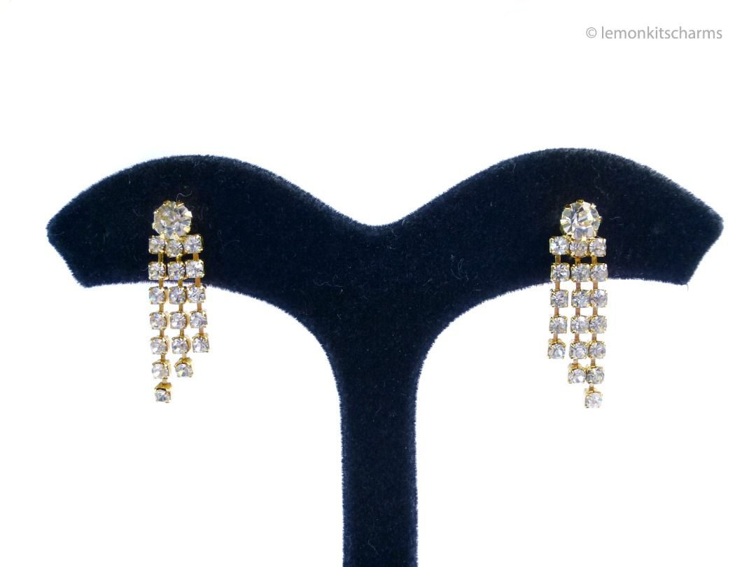 Vintage 1980s Clear Rhinestone Fringe Pierced Earrings, er2679-ci (Category: Earrings) located in Singapore. Submitted by lemonkitscharms (Listing ID 1378720154, Image 1). Description: Vintage 1980s Clear Rhinestone Fringe Earrings, for pierced ears. Minor aging on ear nuts and rhinestones, good condition. Goldtone with sparkly clear rhinestones. Price excludes postage. Check my profile for postage rates. Size: 29 x 8mm - Sorry NO NEGO for 1 item