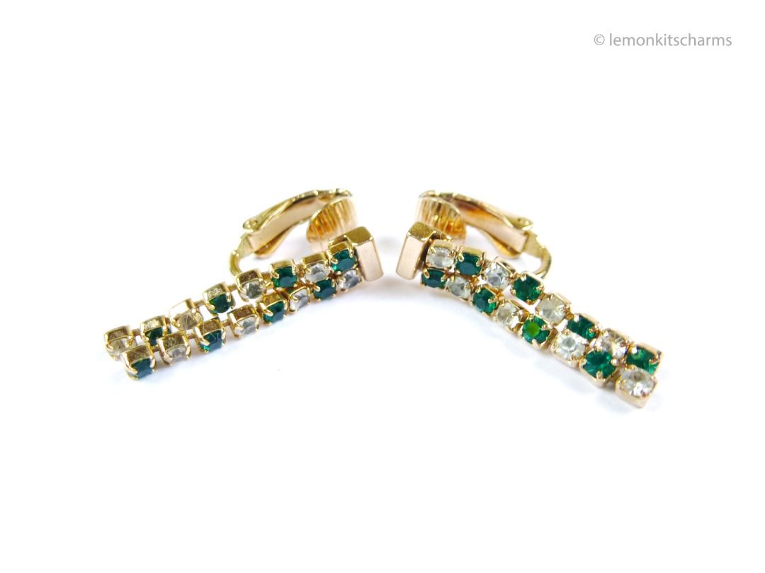 Vintage 1982 Avon Galaxy of Color Clip Earrings, er2678-ci (Category: Earrings) located in Singapore. Submitted by lemonkitscharms (Listing ID 1378720108, Image 1). Description: Vintage 1982 Avon 'Galaxy of Color' Clip Earrings (Simulated emerald). Signed '©Avon'. The clear rhinestones are a bit dulled from dust/age (not super sparkly). Minor aging and wear. Good condition overall. Gold-plated with little green and clear rhinestones. Price exclud