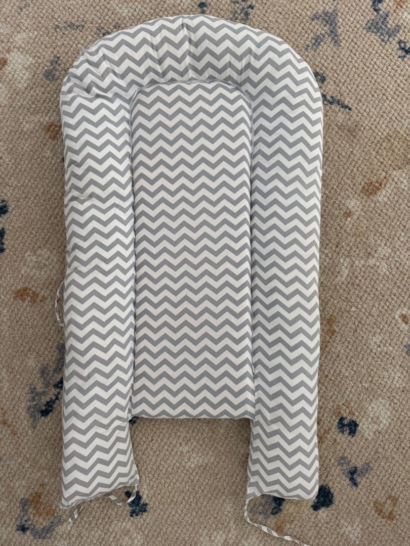 Chevron Pattern Baby Nest (Category: Cots & Cribs) located in Singapore. Submitted by zhualbers (Listing ID 1378748804, Image 2). Description: Soft and comfortable baby nest with a stylish chevron pattern. Features a padded base and raised sides for added security. The nest is designed to provide a cozy and safe space for your baby to rest. Easy to clean and maintain..