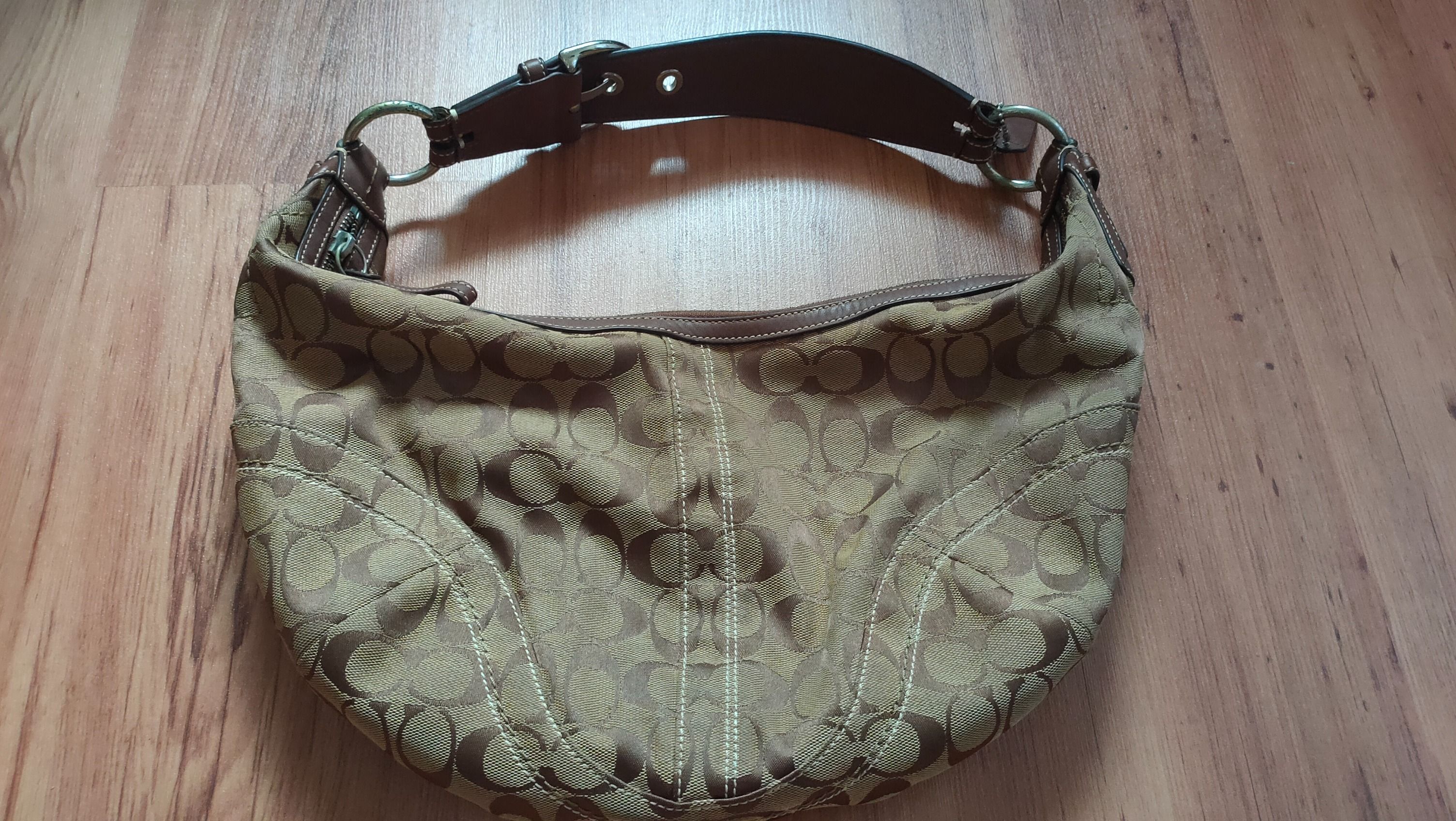Coach Signature Hobo Handbag (Category: Bags & Wallets) located in Singapore. Submitted by jan27d (Listing ID 1378774460, Image 1). Description: Authentic Coach Signature Hobo handbag. Features a brown leather strap and a zip closure. Perfect for everyday use..