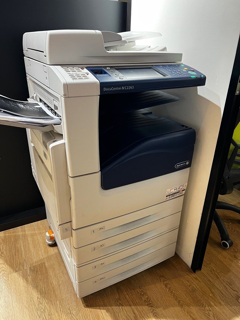 Fuji Xerox Printer -DocuCentre-V C2263 (Category: Printers, Scanners & Copiers) located in Singapore. Submitted by hhhwwwggg (Listing ID 1378735438, Image 1). Description: This is a Xerox photocopier. Can print black & colour , scan document and fax.It appears to be in good condition. It has a blue and black panel on the front. It has a paper tray at the bottom. It looks like it is in an office setting. It has a scanner on the top. It has a scree