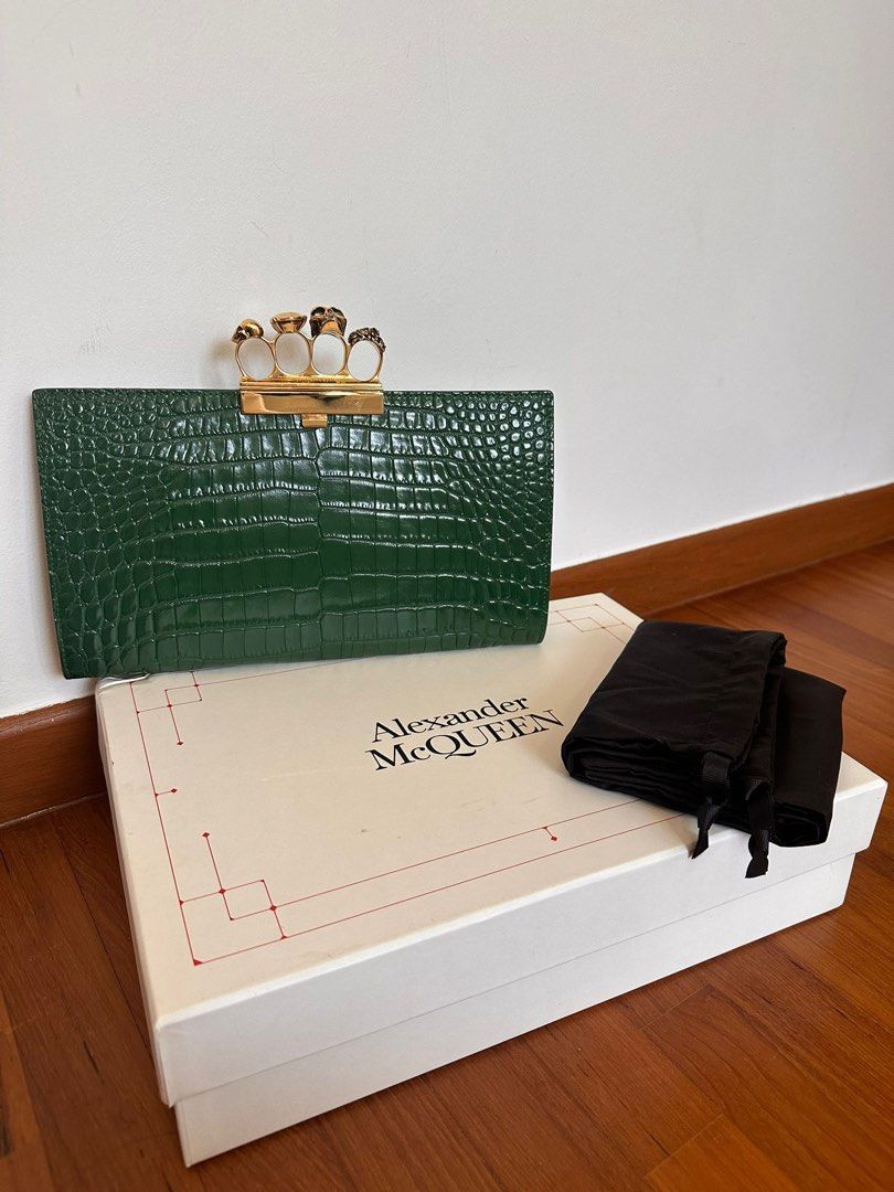 Alexander McQueen Skull Knuckle Clutch (Category: Bags & Wallets) located in Singapore. Submitted by starsinspl54068 (Listing ID 1379093537, Image 1). Description: Authentic Alexander McQueen clutch in excellent condition. Features a striking green crocodile-embossed leather exterior and the iconic skull knuckle clasp. Comes with original box and dust bag. Interior has two compartments with a zip closure..