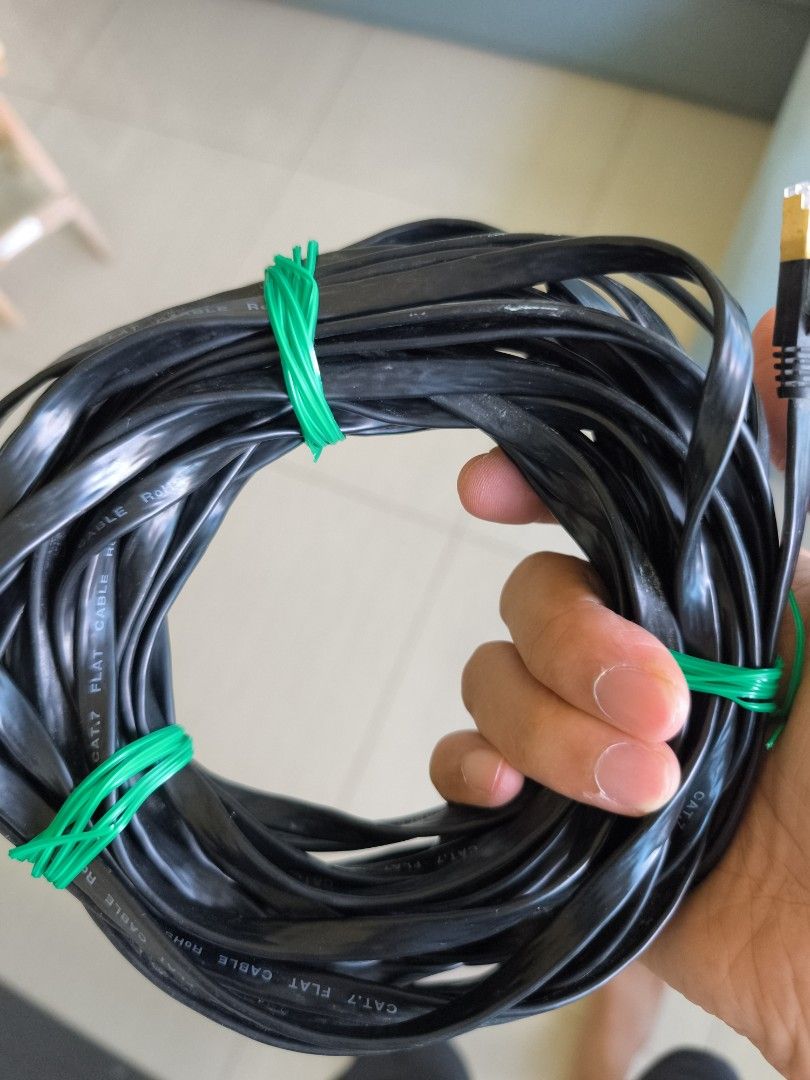 Flat Ethernet Cable (Category: Cables & Adaptors) located in Singapore. Submitted by double_a (Listing ID 1378945985, Image 1). Description: - Black Ethernet cable - Includes green rubber band - Gold-plated connector - Good condition.
