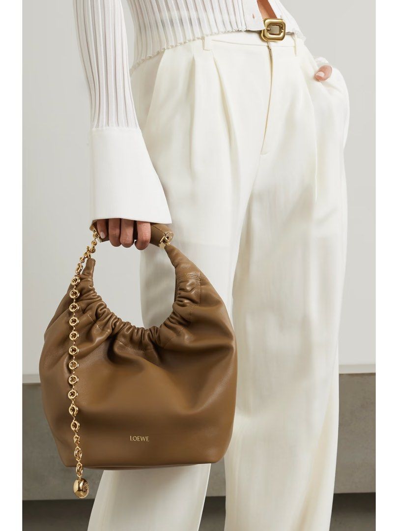 Loewe Squeeze sling bag crossbody bag (Category: Luxury Bags & Wallets) located in Silang. Submitted by girlyouneedthis (Listing ID 1379113912, Image 2). Description: Loewe Squeeze in Brown made from buttery soft leather, this small ‘Squeeze’ style is ruched at the top and has a curved handle with a gold-tone chain. There’s a zipped pocket inside for your phone or keys. Can be a shoulder bag, sling bag and a crossbody bag. Comes with box and dust