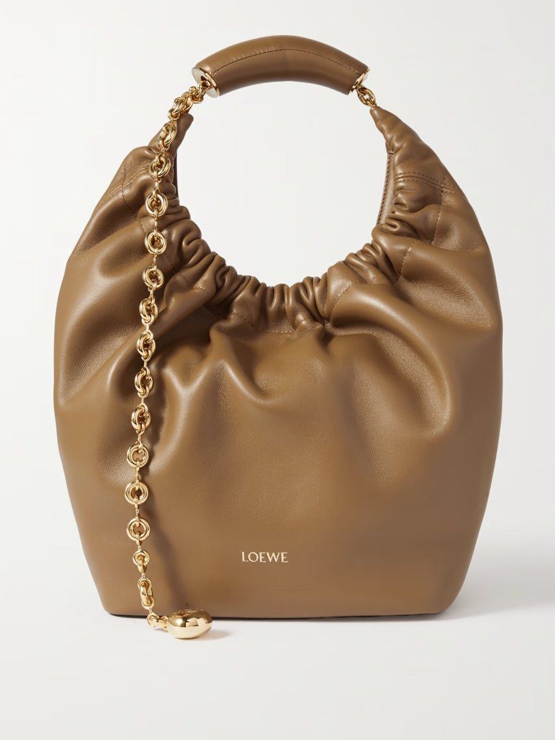 Loewe Squeeze sling bag crossbody bag (Category: Luxury Bags & Wallets) located in Silang. Submitted by girlyouneedthis (Listing ID 1379113912, Image 1). Description: Loewe Squeeze in Brown made from buttery soft leather, this small ‘Squeeze’ style is ruched at the top and has a curved handle with a gold-tone chain. There’s a zipped pocket inside for your phone or keys. Can be a shoulder bag, sling bag and a crossbody bag. Comes with box and dust