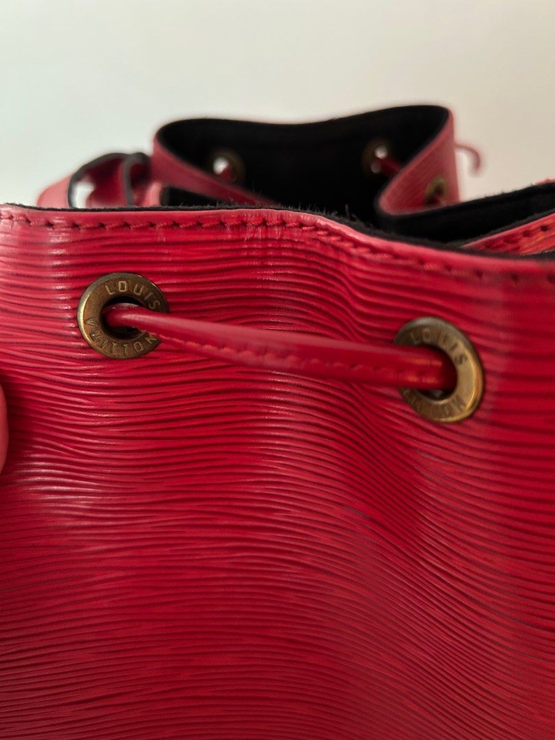 Louis Vuitton Epi Leather Bucket Bag (Category: Bags & Wallets) located in Singapore. Submitted by dor.d (Listing ID 1379055023, Image 3). Description: Vintage Louis Vuitton Epi Leather Bucket Bag in red. Features a drawstring closure and adjustable shoulder strap. Includes dust bag and a free bag organizer. Some signs of wear on the leather, but overall in good condition. Interior is black..