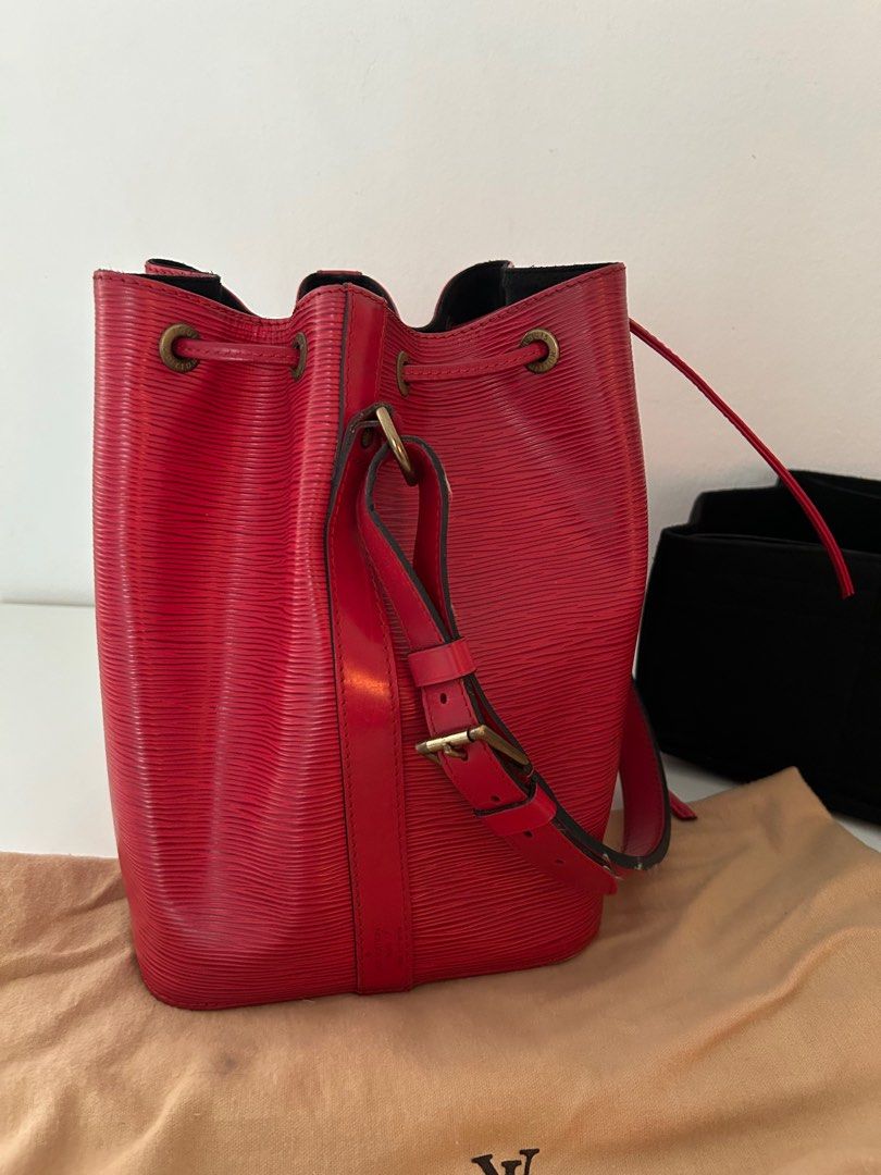 Louis Vuitton Epi Leather Bucket Bag (Category: Bags & Wallets) located in Singapore. Submitted by dor.d (Listing ID 1379055023, Image 2). Description: Vintage Louis Vuitton Epi Leather Bucket Bag in red. Features a drawstring closure and adjustable shoulder strap. Includes dust bag and a free bag organizer. Some signs of wear on the leather, but overall in good condition. Interior is black..