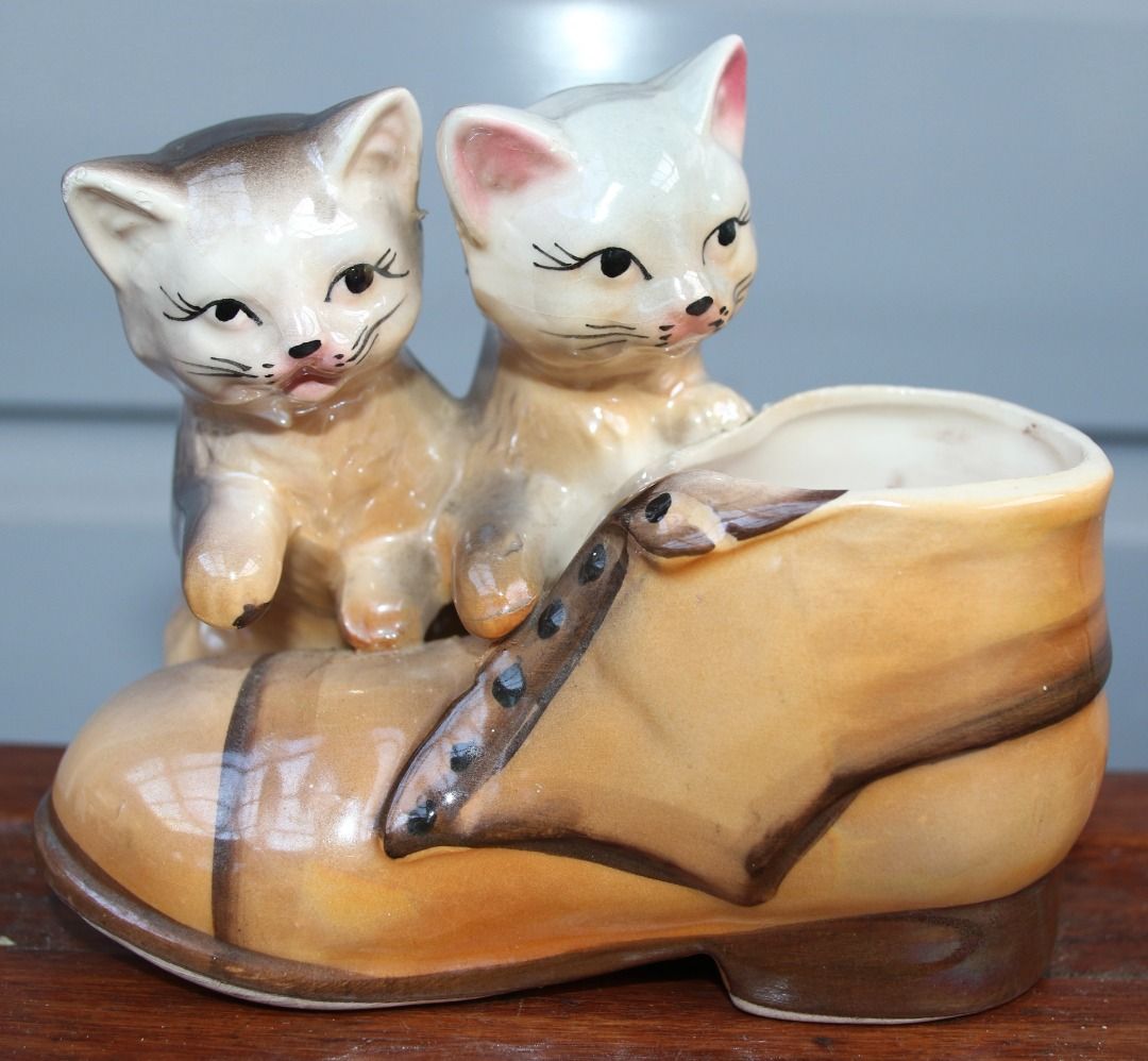 Preloved Vintage Lustre Cat and Boot Vase (Category: Home Decor) located in Burnie. Submitted by tasmanianbeauties (Listing ID 1379046155, Image 1). Description: Preloved Vintage Lustre Cat and Boot Vase Height: 11.5cm Width: 9.8cm Length: 13.5cm Made in Japan. A ceramic vase with cats and a boot. It is in great vintage condition. It is unknown how watertight it is. This item is listed on my website, www.tasmanianbeauties.com.au, with Paypal and 