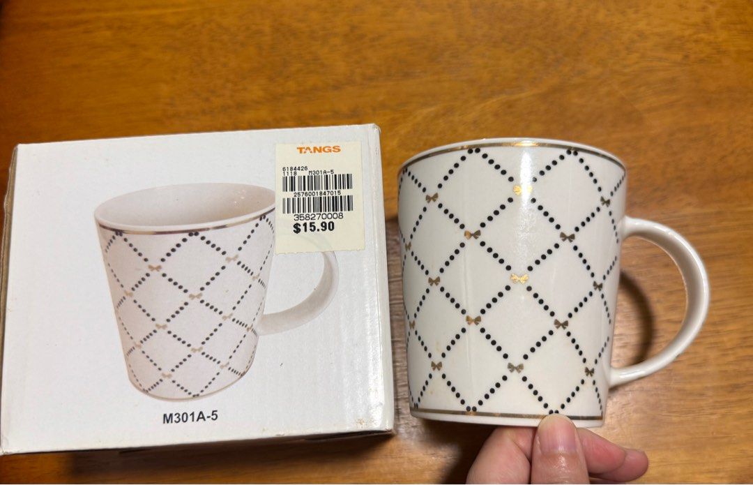 Tangs Bow Pattern Mug (Category: Coffee & Tea Tableware) located in Singapore. Submitted by creativelycute (Listing ID 1379030438, Image 1). Description: Elegant white mug with a charming bow pattern. Features gold accents and a comfortable handle. Comes with original box. Perfect for enjoying your favorite beverages in style..