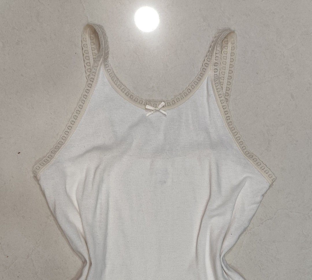 Hush Puppies White Lace cami y2k Tank Top camisole coquette (Category: Sleeveless) located in Singapore. Submitted by jamjamies (Listing ID 1379102006, Image 1). Description: measurements ptp: fits xxs-s bust: 32cm length (from armpit to hem): 29cm Hush Puppies tank top, 100% cotton Excellent condition, never worn out before. pretty lace trim and bow detail also has lettuce hem at the bottom!!! super comfortable and versatile, for layering or wea