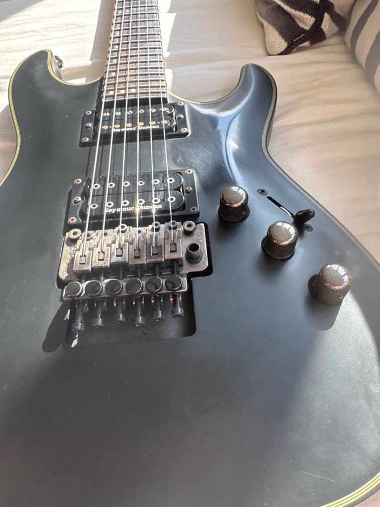 Schecter Electric Guitar (Category: Musical Instruments) located in Singapore. Submitted by zackbaig (Listing ID 1378071678, Image 3). Description: Used Schecter electric guitar. Appears to be in good working condition. Features a Floyd Rose tremolo system and humbucker pickups. Some signs of wear and tear visible on the body. Great for rock and metal. No guitar case bring ur own bag if u pay 150 will include gigablade bag .