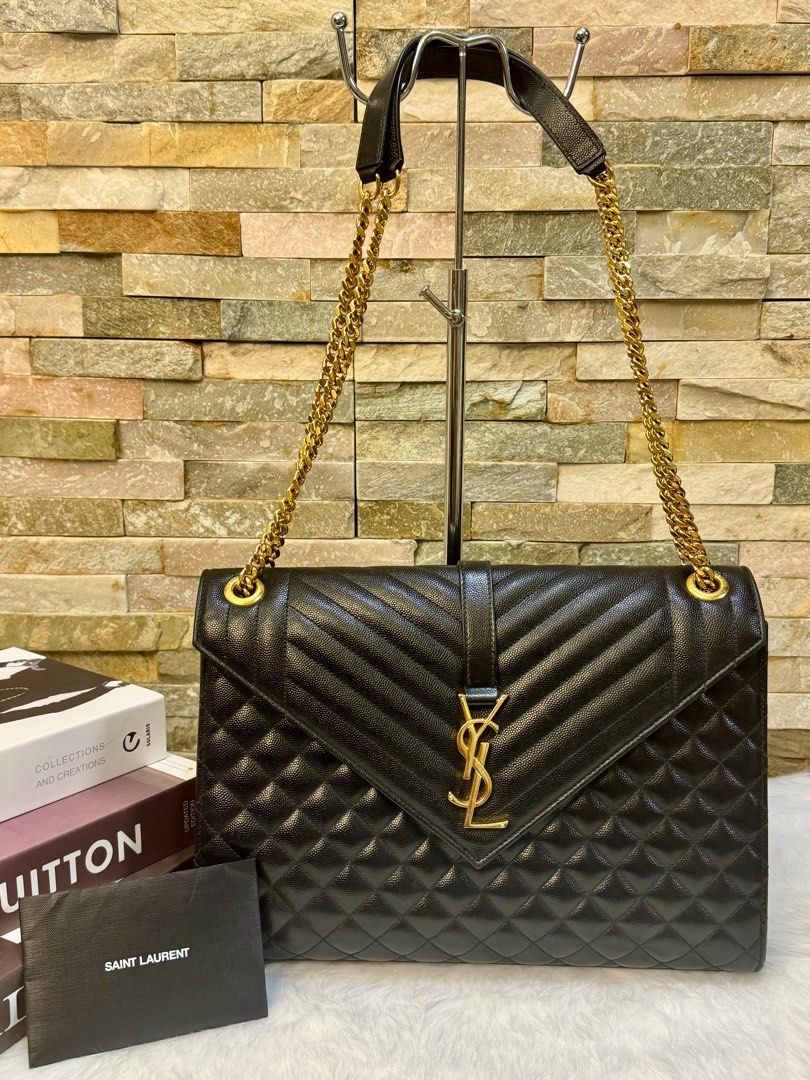 YSL envelope large bag (Category: Luxury Bags & Wallets) located in Taguig. Submitted by angelbellaclaire (Listing ID 1379247465, Image 2). Description: Make a bold statement with the Saint Laurent Large Envelope in black caviar leather, YSL monogram, and versatile chain strap. Approx. size: 12.2” x 8.6” x 2.7”. Perfect for work to weekend.” Inclusion: dustbag, care card and receipt.