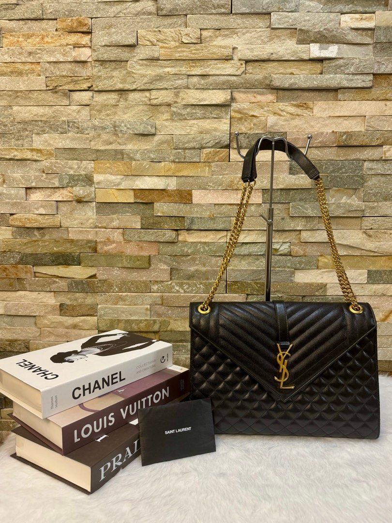 YSL envelope large bag (Category: Luxury Bags & Wallets) located in Taguig. Submitted by angelbellaclaire (Listing ID 1379247465, Image 1). Description: Make a bold statement with the Saint Laurent Large Envelope in black caviar leather, YSL monogram, and versatile chain strap. Approx. size: 12.2” x 8.6” x 2.7”. Perfect for work to weekend.” Inclusion: dustbag, care card and receipt.