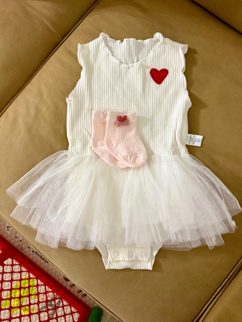 Baby Girl White Romper with Tutu Skirt and Socks (Category: Babies & Kids Fashion) located in Singapore. Submitted by yinyin503487414 (Listing ID 1379477948, Image 1). Description: Adorable baby girl romper with a tutu skirt and matching socks. Features a ribbed bodice with a cute heart detail. Perfect for special occasions or everyday wear. Includes a pair of pink socks with bow accents. Snap closure for easy diaper changes..