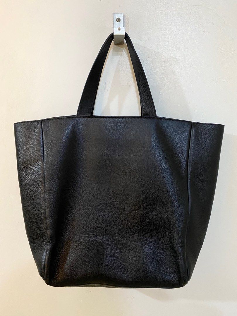 Balenciaga Leather Logo Tote Bag (Category: Luxury Bags & Wallets) located in Pasig City. Submitted by capsulecollection (Listing ID 1379483064, Image 3). Description: Balenciaga Leather Logo Tote Bag Color: Black Tonal stitching White printed embossed logo at front face Four flap top handles to serve as shoulder bag or hand bag Open top One main compartment with two slip zippered pockets Size: 13.5” length x 5” depth x 14” height 7” and 12” top 