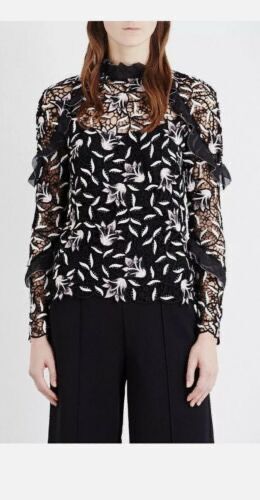 Black Lace Top with Floral Embroidery (Category: Blouses) located in Singapore. Submitted by malaikahasan (Listing ID 1379384365, Image 1). Description: Elegant black lace top featuring intricate floral embroidery. It has long sleeves and a high neckline with ruffle detailing. The top appears to be in excellent condition, perfect for a special occasion or to elevate your everyday style..