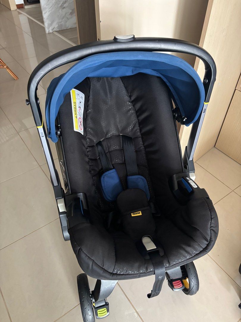 Doona+ Infant Car Seat & Stroller - Black (Category: Strollers) located in Singapore. Submitted by e.vieyen (Listing ID 1379433631, Image 3). Description: This Doona+ car seat and stroller is in great condition. It features a sleek black design with a blue canopy and seat padding. The wheels show some signs of use, but the stroller is fully functional. Includes all safety features and is easy to use. Includes pouch! This car seat expired this yea