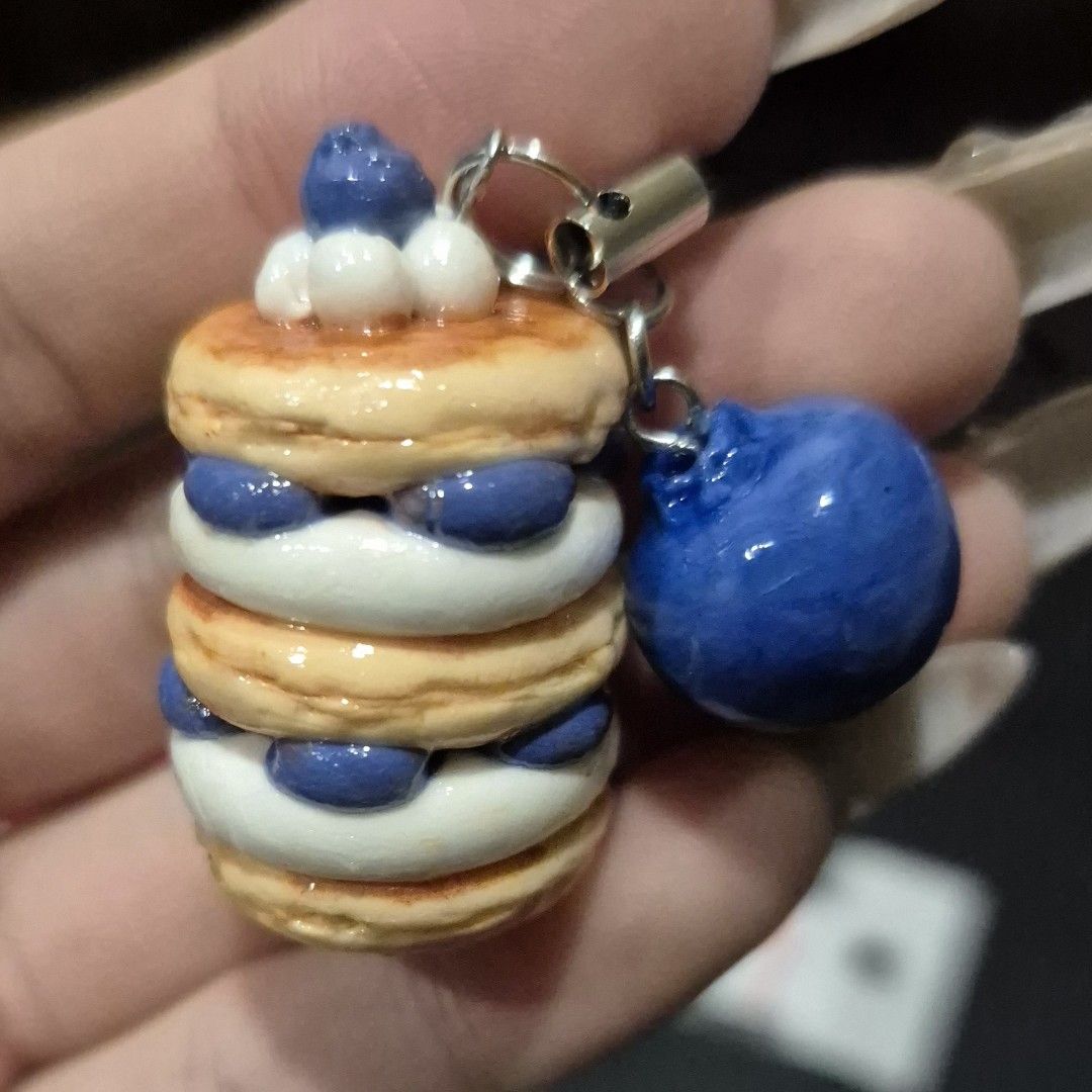 Handmade Clay Blueberry Pancake Charm (Category: Handmade Craft) located in Singapore. Submitted by misteaclay (Listing ID 1379379804, Image 2). Description: - Handmade waterproof glazed air dry clay charm - 3.5 cm tall x 2 cm wide (Please allow room for adjustment as all charms are made by hand) - Features a stack of pancakes with whipped cream and blueberry filling - Includes a single blueberry charm - Perfect for phones, bags, or keys - Unique