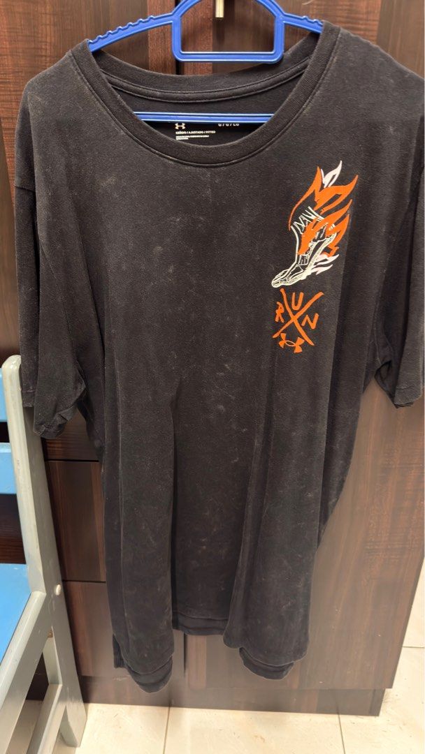 Under Armour Run T-Shirt (Category: Tshirts & Polo Shirts) located in Singapore. Submitted by xction (Listing ID 1379482368, Image 1). Description: Black Under Armour t-shirt with a unique graphic design on the front and back. Features a crew neck and short sleeves. The shirt shows signs of wear, but the print is still vibrant. Perfect for casual wear or workouts..