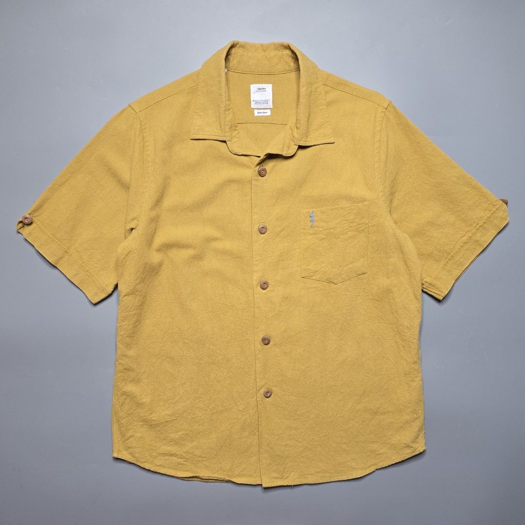 Visvim - SS18 Ellas Shirt - Mustard (Category: Formal Shirts) located in Malabon City. Submitted by buynflex (Listing ID 1379441729, Image 1). Description: Visvim - SS18 Ellas Shirt S/S E. W. - Mustard Size 2 (W 22 X L 28.5 Inches) Gently Used Very Good Condition Product Information Short-sleeved shirt made from linen-silk-cotton blend fabric. One wash Hand stitched detail Original patch detail Original bamboo buttons.