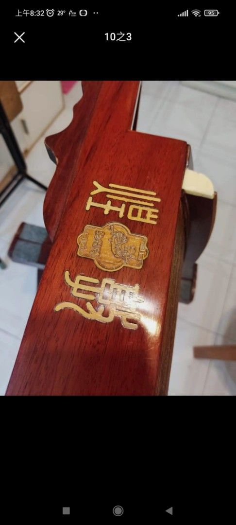 敦煌古箏 （分類：復古收藏品）位於 Hong Kong。 由 659888 提交（商品編號 1386106936，圖片 7）。簡介： 這是一把精美的古箏，木質結構，雕刻精美。琴身有文字雕刻，琴頭有裝飾。附帶琴架。琴身整體呈棕色，細節處有金色裝飾。琴身背面有標籤，標示了型號等信息。琴弦完整，適合演奏。。