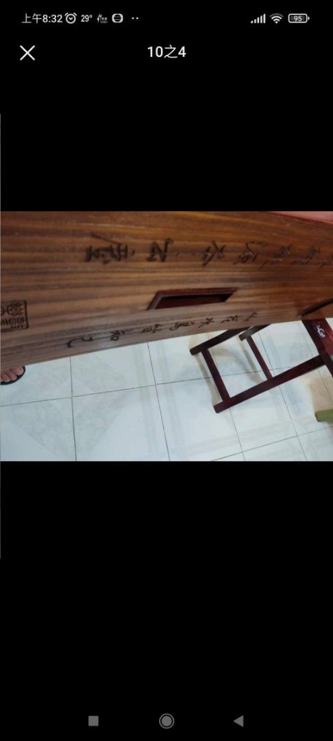 敦煌古箏 （分類：復古收藏品）位於 Hong Kong。 由 659888 提交（商品編號 1386106936，圖片 3）。簡介： 這是一把精美的古箏，木質結構，雕刻精美。琴身有文字雕刻，琴頭有裝飾。附帶琴架。琴身整體呈棕色，細節處有金色裝飾。琴身背面有標籤，標示了型號等信息。琴弦完整，適合演奏。。