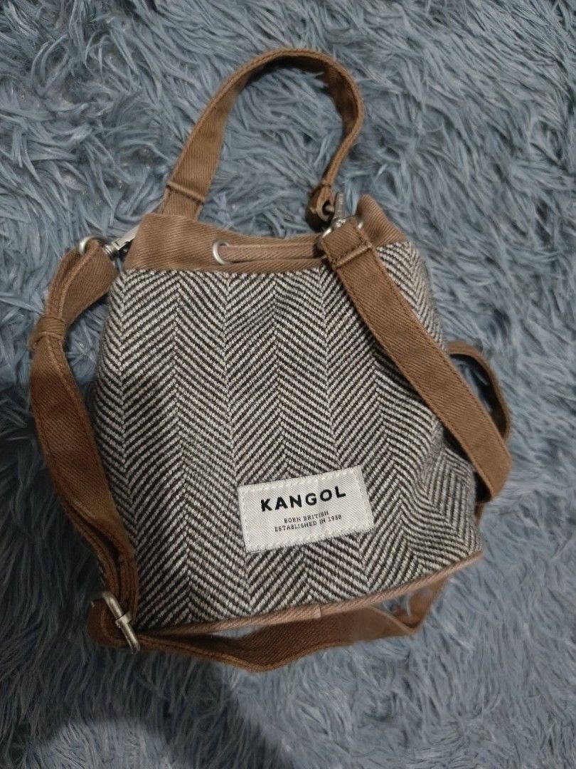 Kangol Brown Wool 2-Way Bucket Bag (Category: Cross-body Bags) located in Lucena. Submitted by sha.lane (Listing ID 1386270986, Image 3). Description: 👜 Brand: Kangol 🤎 Color: Brown 🪡 Material: Wool 🎒 Style: 2-way bucket bag — can be carried by hand or worn as a sling 📏 Size: Height 7" × Width 7-8" × Base 4" 🗂 Pockets: 1 zip pocket inside 🔒 Closure: Drawstring bucket-style closure (note: minor rust on metal part of the closure) ✨ Details: 