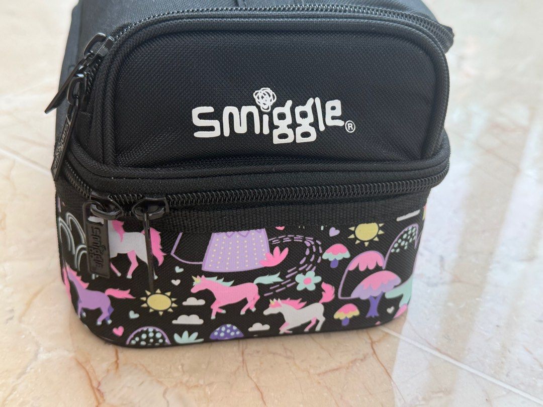 Smiggle Unicorn Double Decker Lunchbox (Category: Babies & Kids Fashion) located in Singapore. Submitted by Behappy (Listing ID 1386277315, Image 2). Description: - Smiggle lunchbox, perfect for school or outings. - Features a fun unicorn print. - Double-decker design for food and drinks separation. - Includes a name tag inside. - Zippers in good working condition..
