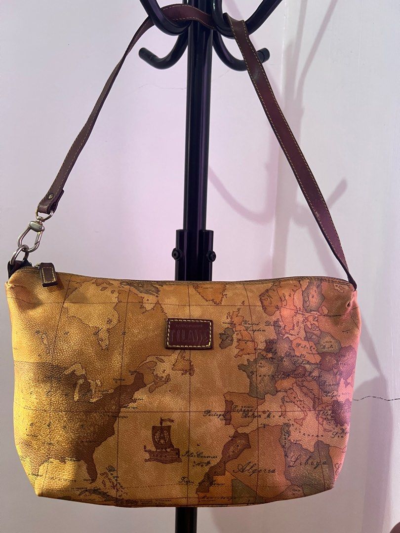 Alviero Martini Geo Collection Shoulder Bag (Category: Luxury Bags & Wallets) located in Santiago. Submitted by mariesimon (Listing ID 1387238180, Image 1). Description: Monogram canvas Zipper closure Handle shows visible darkening Interior needs cleaning, with signs of usage Faded hardware Orange mark visible on the back of the bag .