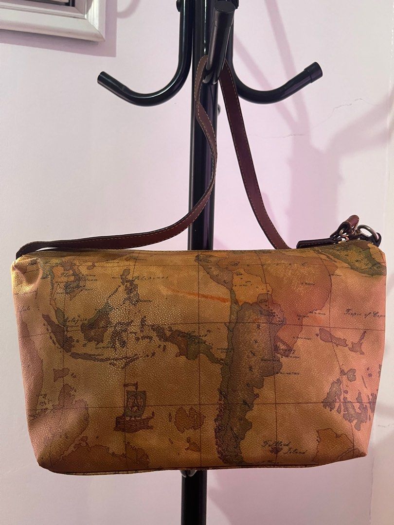 Alviero Martini Geo Collection Shoulder Bag (Category: Luxury Bags & Wallets) located in Santiago. Submitted by mariesimon (Listing ID 1387238180, Image 3). Description: Monogram canvas Zipper closure Handle shows visible darkening Interior needs cleaning, with signs of usage Faded hardware Orange mark visible on the back of the bag .
