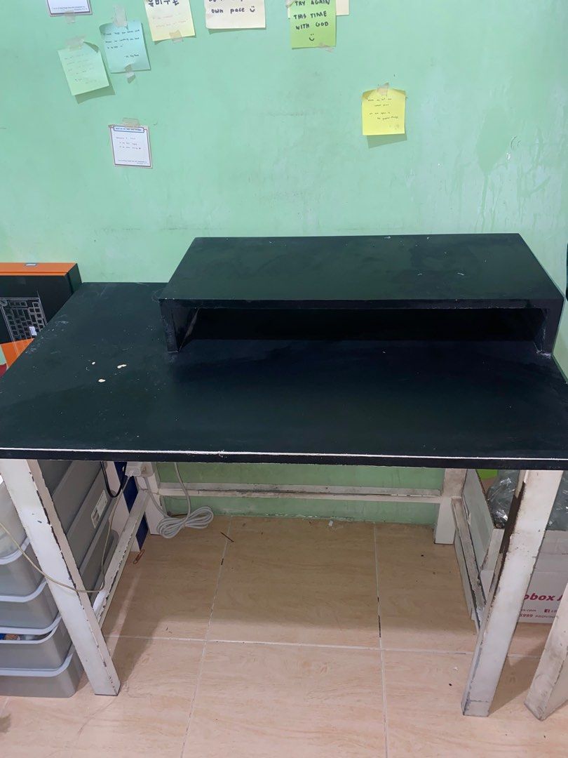 Black Desk Table with elevated plank (without the small shelf on the side) (Category: Tables & Sets) located in Marikina City. Submitted by preloved_sars (Listing ID 1387176573, Image 2). Description: Bought this at 8,000php to support jeepney drivers during pandemic in 2021. Super sturdy and can carry up to 70kg weight. (Yes can carry one person) Price still negotiable The table needs repainting Made of sturdy wood and bakal Has holes good for p