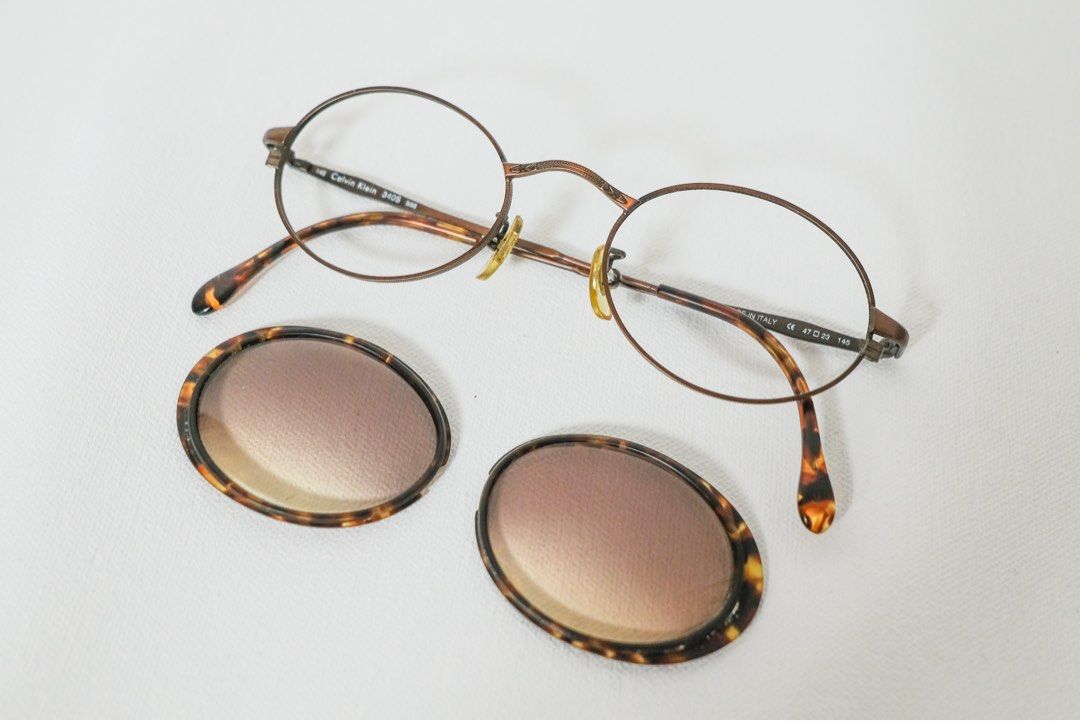 CALVIN KLEIN Vintage Sunglass (Category: Sunglasses & Eyewear) located in Pasig City. Submitted by space.byp (Listing ID 1387172208, Image 2). Description: CALVIN KLEIN Vintage Sunglass. Authentic. Made in Italy. This pair of vintage Calvin Klein sunglasses showcases a unique and elegant design, blending classic craftsmanship with thoughtful utility. Round, full-rim silhouette. The temples and bridge are made of a slim metal in a bronze/copper to