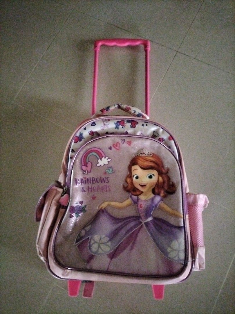 Sofia the First Rolling Backpack (Category: Backpacks) located in Singapore. Submitted by skullman031977 (Listing ID 1387753286, Image 1). Description: - Adorable Sofia the First rolling backpack. - Perfect for young children. - Features a pull-up handle and wheels. - Can be used as a regular backpack. - Includes a main compartment and side pockets..