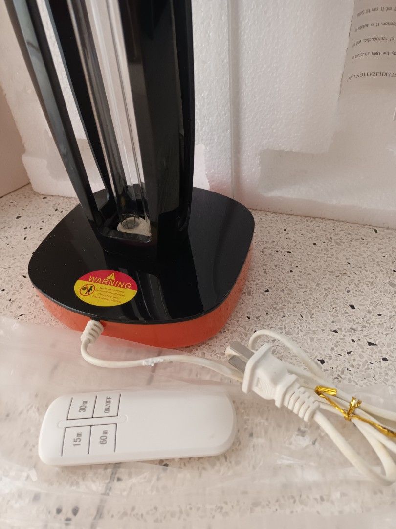 UV light (Category: Other Home Appliances) located in Singapore. Submitted by gogay (Listing ID 1388211713, Image 2). Description: - Sleek, modern design in black and orange. - Includes a convenient remote control for easy operation. - Used but in good condition. - Ideal for disinfecting and purifying your space..