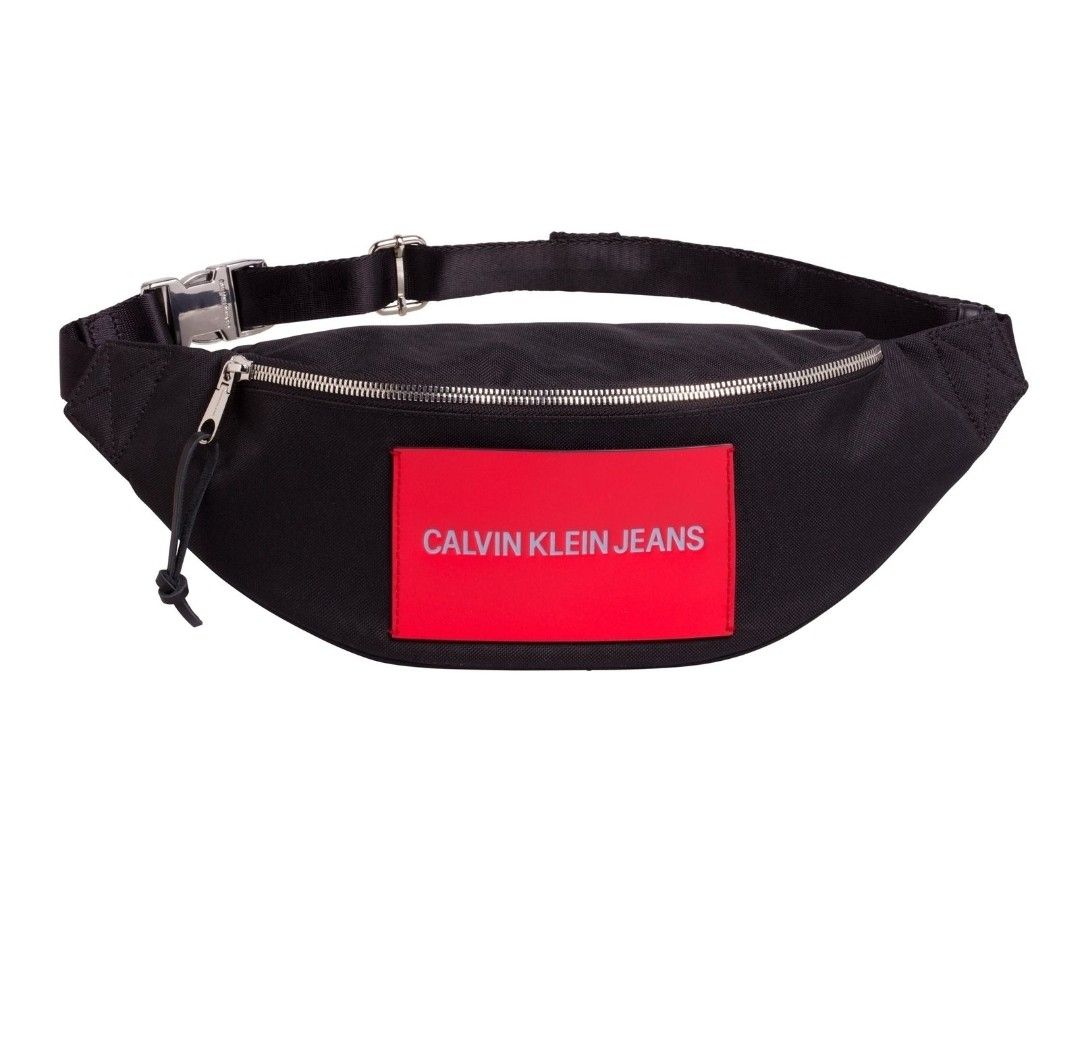 Calvin Klein Waistbag Black (Category: Luxury Bags & Wallets) located in Manila. Submitted by rdeall (Listing ID 1388434920, Image 2). Description: Black Calvin Klein Jeans waist bag, also known as a fanny pack or bum bag, from the Sport Essentials or Street Pack collection. Description: Color and Material: The bag is primarily black, made from a fabric that can include recycled polyester or nylon. Design: It features a curved, streamlined design