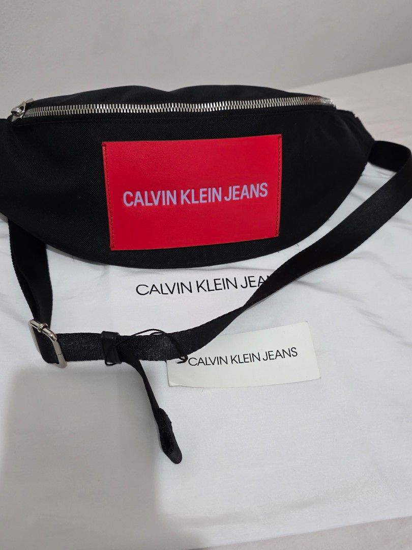 Calvin Klein Waistbag Black (Category: Luxury Bags & Wallets) located in Manila. Submitted by rdeall (Listing ID 1388434920, Image 3). Description: Black Calvin Klein Jeans waist bag, also known as a fanny pack or bum bag, from the Sport Essentials or Street Pack collection. Description: Color and Material: The bag is primarily black, made from a fabric that can include recycled polyester or nylon. Design: It features a curved, streamlined design