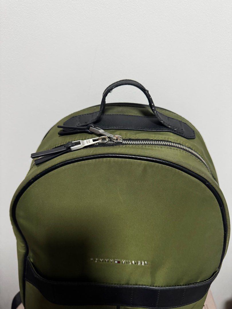 Original Tommy Hilfiger Backpack (Category: Backpacks) located in Dasmarinas. Submitted by JD1997 (Listing ID 1388318015, Image 2). Description: This is an original Tommy Hilfiger Backpack in army green color. A combination of Nylon and Leather material with metal-attached TH-spelled out logo. This bag has laptop compartment that can fit up to 15 inches. with in-pocket inside. Honest issues: - minor zipper discoloration (unnoticeable) - leather s