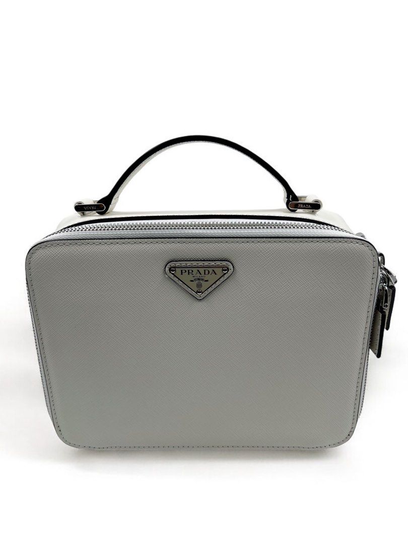 ⚜️Prada Saffiano Brique bag - White (Category: Luxury Bags & Wallets) located in Makati City. Submitted by 90sangel (Listing ID 1388695608, Image 1). Description: •Item: Prada Brique Saffiano bag 👜🤍 •Size: Medium 8" x 6" •Condition: Excellent! rare and hard to find! 😩✨ *This chic crossbody bag is crafted of Prada signature saffiano cross-grain leather in black. Classic & perfect for travels! 💼🖤.
