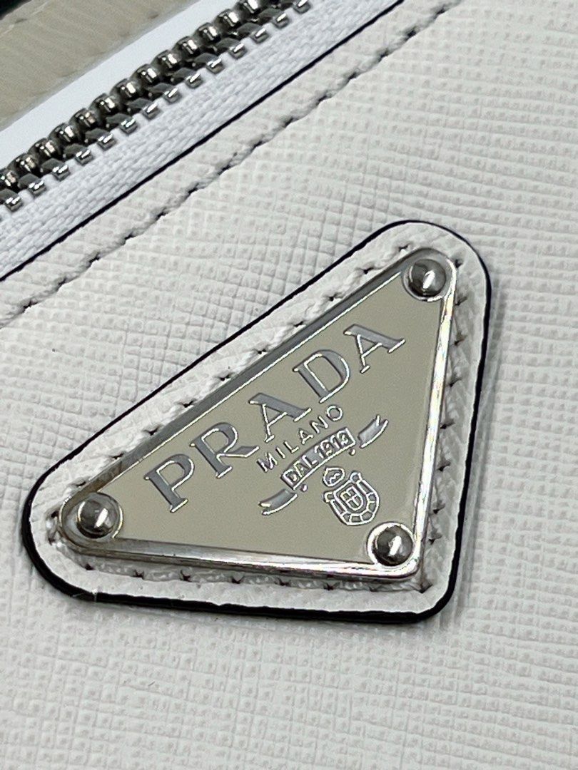 ⚜️Prada Saffiano Brique bag - White (Category: Luxury Bags & Wallets) located in Makati City. Submitted by 90sangel (Listing ID 1388695608, Image 3). Description: •Item: Prada Brique Saffiano bag 👜🤍 •Size: Medium 8" x 6" •Condition: Excellent! rare and hard to find! 😩✨ *This chic crossbody bag is crafted of Prada signature saffiano cross-grain leather in black. Classic & perfect for travels! 💼🖤.