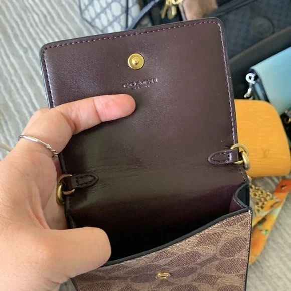 Coach Phone/Card Sling (Category: Luxury Bags & Wallets) located in Baguio. Submitted by thrift_saver07 (Listing ID 1388940646, Image 3). Description: Signature coated canvas and refined calf leather Snap closure Four outside credit card slots Detachable strap with 23" drop for shoulder or crossbody wear 4 1/4" (L) x 7" (H) x 1 1/4" (W) Style No. 76357.