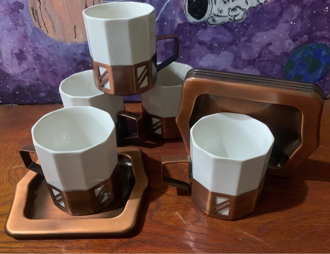 Coffee/ Tea Cup Set (Category: Coffee & Tea Tableware) located in San Juan City. Submitted by fieldofgold19 (Listing ID 1388943411, Image 1). Description: 5 ceramic cups w/ metallic holder Metallic saucers Not sure if the metal is copper.