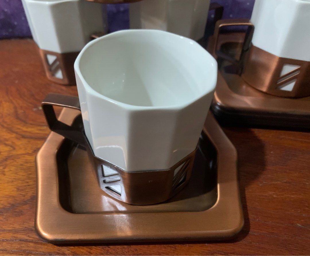 Coffee/ Tea Cup Set (Category: Coffee & Tea Tableware) located in San Juan City. Submitted by fieldofgold19 (Listing ID 1388943411, Image 2). Description: 5 ceramic cups w/ metallic holder Metallic saucers Not sure if the metal is copper.