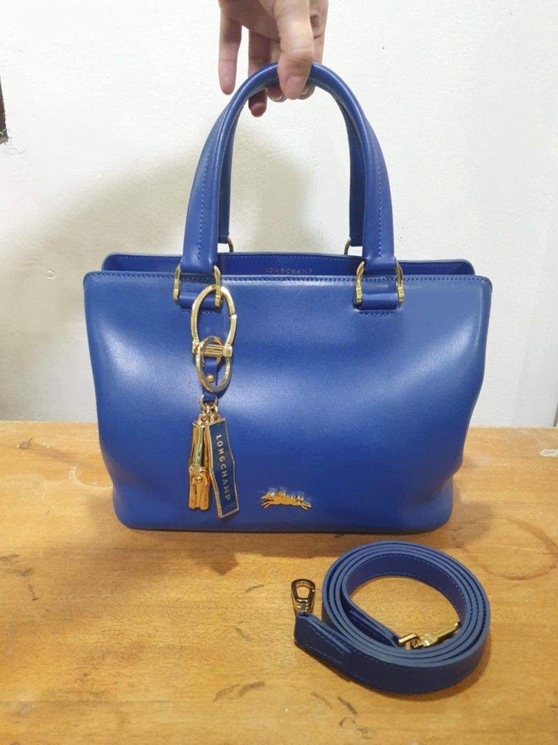Longchamp Honore 404 Hand Bag (Category: Luxury Bags & Wallets) located in Pasig City. Submitted by ldcayas (Listing ID 1389048210, Image 1). Description: Longchamp Honore 404 Handbag Royal Blue leather with gold hardware With detachable strap Size small approx LWH 11" x 5" x 8" With dustbag, carecard and charm No receipt, bought in Paris RFS: decluttering MOP: BPI Bank Transfer/ Gcash.