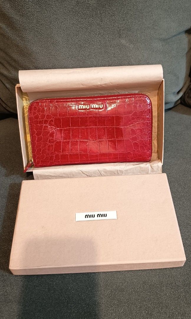 Authentic Miu Miu Red Croc Embossed Leather Zip Around Wallet (Category: Luxury Bags & Wallets) located in Binangonan. Submitted by retrovintagesourceph (Listing ID 1389381726, Image 1). Description: This wallet from Miu Miu is one creation a fashionista like you must own. It has been wonderfully crafted from croc-embossed leather and it flaunts a red shade. It also comes equipped with a zip around that opens to reveal multiple slots and a zipper